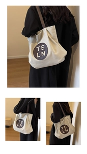 Detail of canvas tote bag showing brown leather handles and circular logo patch