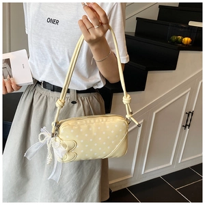 Détail du sac à bandoulière jaune à pois avec bord nuage et nœud en perles