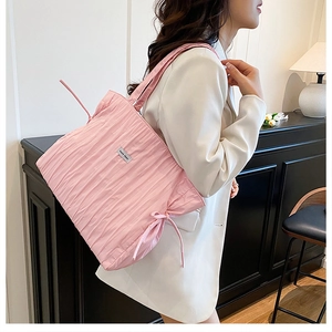 Dettaglio borsa shopper rosa plissettata con coulisse a fiocco e placca logo argentata