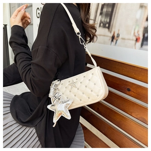 Detailed view of cream quilted shoulder bag with silver star charm and rhinestone studs