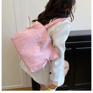 Dettaglio della borsa tote rosa trapuntata con trama pieghettata e coulisse laterali