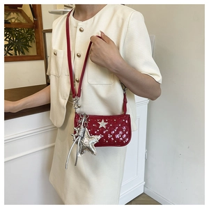Detail of red patent leather shoulder bag with silver star studs and Y2K aesthetic