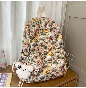 Detailed view of the cute 3D knit bear and flower print on the beige school backpack
