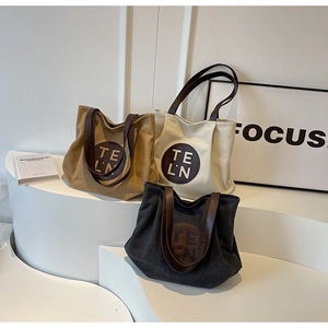 Detailed view of canvas tote bags in khaki, beige, and gray with premium leather straps