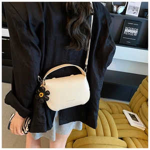 Creamy white litchi pattern leather handbag shown on model for a trendy daily look