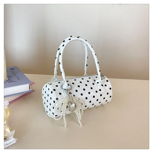 Vue détaillée du sac cylindrique à pois avec nœud en perles et pendentif cœur