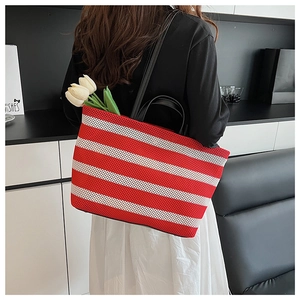 Détail du cabas en maille rayé rouge et blanc avec anses et bandoulière en cuir noir