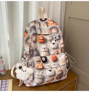 Detail of grey student backpack with cute cartoon animal prints and plush bear charm