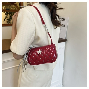 Detail of red quilted patent leather crossbody bag with silver rhinestones and star accent