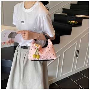 Detailaufnahme der rosa Handtasche mit Blasenstruktur, Schleifenmuster und Gänseblümchen