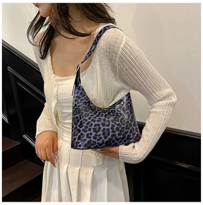 Detail of purple leopard print baguette bag on shoulder with Y2K vintage style