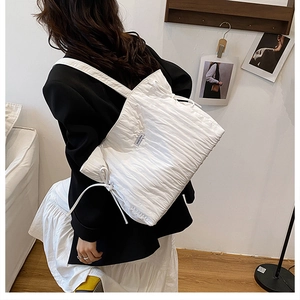 Dettaglio della borsa tote bianca a pieghe con coulisse e decorazione a fiocco