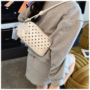Détail du sac à pois avec nœud élégant chaîne en perles et texture de cuir doux