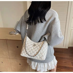 Détail du sac bandoulière blanc matelassé avec emblème étoile et chaîne argent