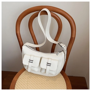 Detailed view of white crescent moon shoulder bag with functional multi-pocket design