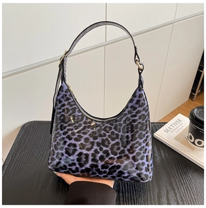 Detail of purple leopard print patent leather hobo bag with adjustable black strap