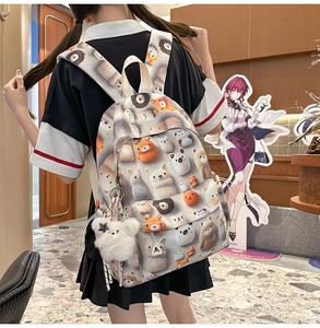 Detail view of cartoon print backpack with thick padded straps and a plush bear charm