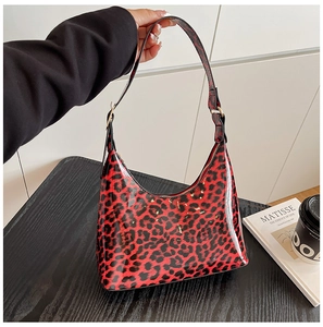 Detail showing red leopard print hobo bag in glossy patent leather with adjustable strap