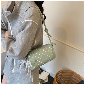 Vue détaillée du sac porté épaule vert clair à pois avec nœud en dentelle et perle