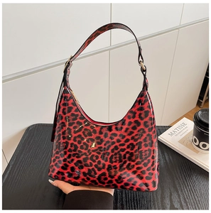Macro detail of glossy red leopard print hobo bag with sleek patent leather texture