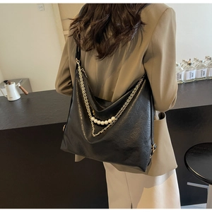 Detail of black tote with pearl chain and crinkled matte leather texture for women