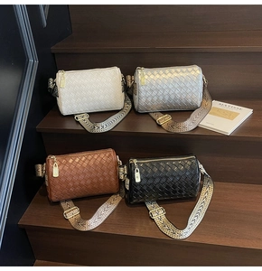 Detail of woven pillow bags in four colors with geometric straps on wooden steps