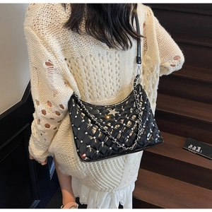 Détail du sac à bandoulière matelassé noir avec strass et chaîne argentée sur modèle