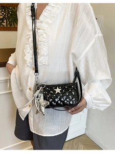 Quilted black patent leather crossbody bag with silver stars and metallic star charm