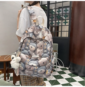 Detail of cute 3D cartoon animal prints and white daisy patterns on a blue school backpack