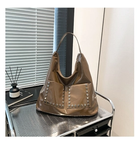 Detail of vintage tote bag featuring shiny patent leather and silver hexagonal rivets