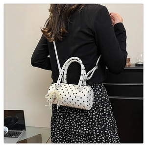 Détail du sac cylindrique à pois blancs avec nœud en perles et fine bandoulière