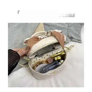 Interior view of mini beige quilted bag with gold chain showing storage capacity