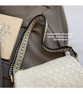 Detail of white woven pillow bag featuring an adjustable geometric wide shoulder strap