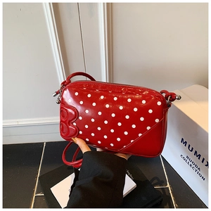 Détail du mini sac rouge à pois avec lettre B en relief et fermeture éclair argentée