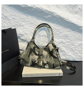Gros plan d'un sac sous le bras camouflage avec fermoir rotatif en métal et texture durable