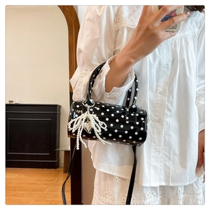 Détail du sac cylindrique à pois avec breloque nœud en perles et bandoulière