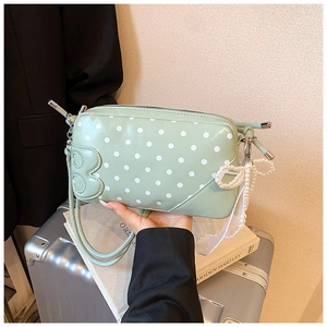 Détail du sac à pois vert menthe montrant le nœud en perles et le ruban en dentelle