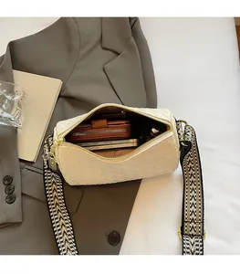 Spacious interior of beige woven cylinder bag showing storage for phone and wallet