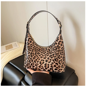 Detail of glossy leopard print hobo bag with gold zipper and stylish integrated handle