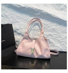 Détail du sac sous l'aisselle en cuir brillant rose avec boucles dorées et poignées