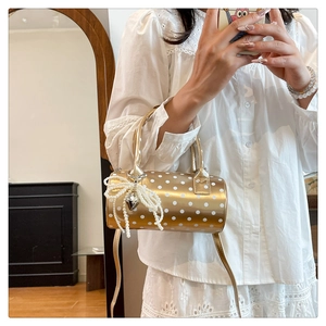 Sac cylindrique doré champagne avec pois blancs et charm nœud en perles élégant