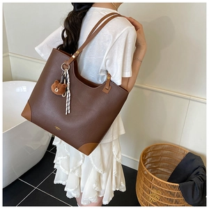 Close-up of brown litchi pattern tote bag featuring a cute plush bear and striped scarf
