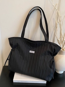 Grande borsa tote in nylon nero plissettato con coulisse ed etichetta tessuta minimalista
