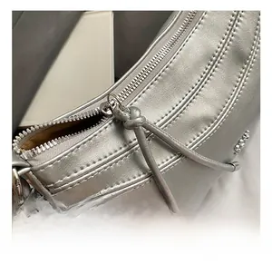 Détails du sac en cuir métallisé argenté avec coutures de précision et zip métallique