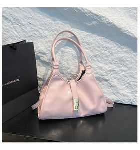 Détail du sac à main rose clair avec boucle dorée élégante sur un décor texturé chic