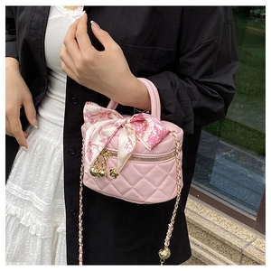 Detail of pink quilted leather bag with gold flower charm and silk scarf handle