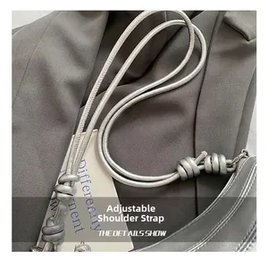 Détail de la bandoulière réglable avec nœud décoratif sur un sac en cuir argenté
