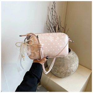 Détail du sac à main rose à pois avec pendentif perle et lettre B brodée en relief