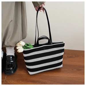 Vue détaillée d'un sac cabas rayé avec texture en maille et design à double poignée