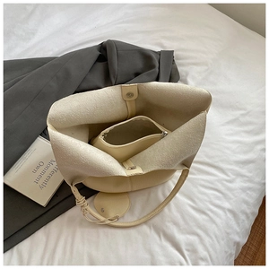 Detail view of the beige lychee pattern tote bag with inner pouch and magnetic closure